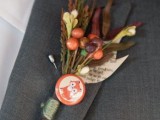 a vintage wedding boutonniere of colorful grasses and leaves, faux berries and a fox badge is a lovely vintage groom accessory