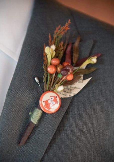 a vintage wedding boutonniere of colorful grasses and leaves, faux berries and a fox badge is a lovely vintage groom accessory