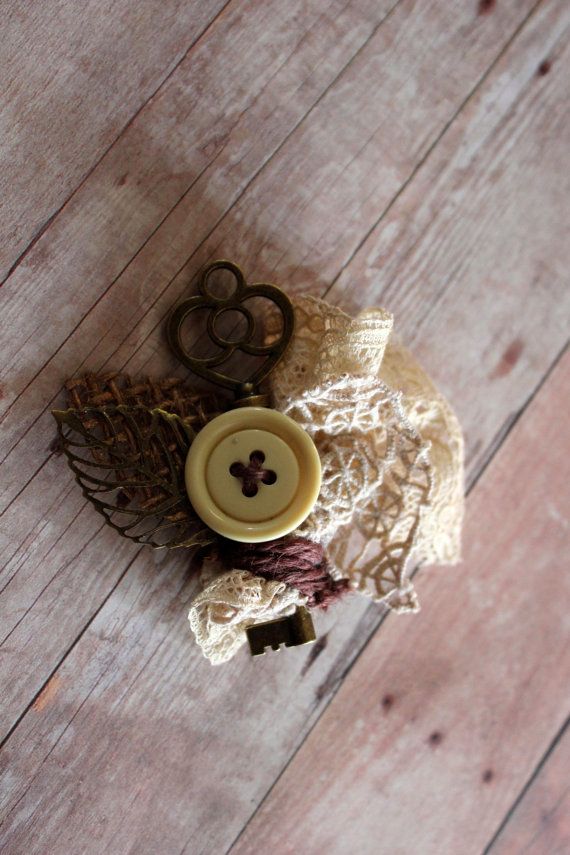 a vintage wedding boutonniere of lace and leaves, a vintage key and a button is a stylish idea for a shabby chic wedding