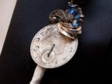 a vintage clock face with swirls and beads, a metal flower and a wrap is a creative idea with plenty of chic