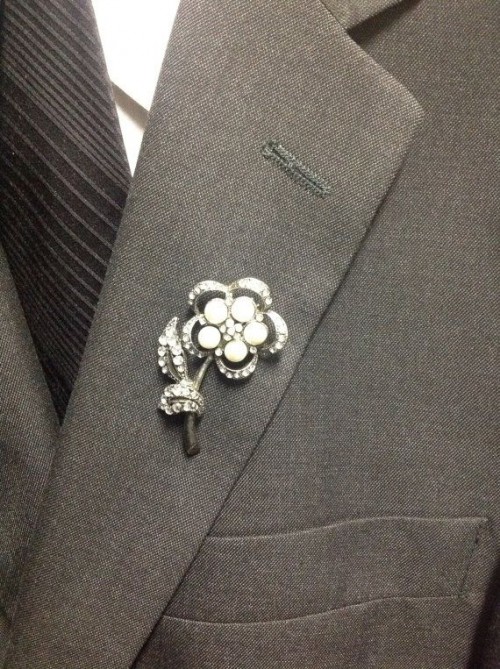 a vintage bejeweled pin shaped as a flower can be rocked as a chic and fun wedding boutonniere
