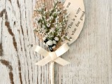 a vintage rustic wedding boutonniere of blooms, a paper and a burlap leaf and a ribbon bow is a lovely idea for a vintage wedding