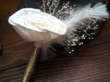 a vintage wedding boutonniere of a white fabric bloom, a feather, some branches is a creative and chic accessory for a vintage wedding
