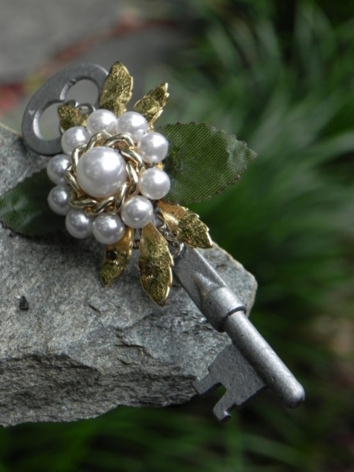 a vintage wedding boutonniere of a vintage key, pearls and chain, gold leaves is a gorgeous idea for a vintage wedding