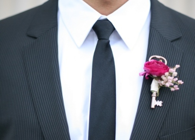 a vintage wedding boutonniere of a key, baby's breath and a fuchsia rose is a cool idea with a touch of color