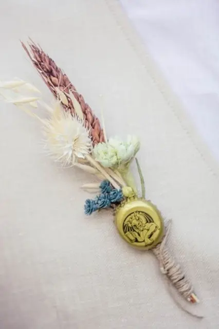 a unique vintage wedding boutonniere of colorful dried blooms and a bottle lid plus twine is a lovely vintage accessory for a wedding