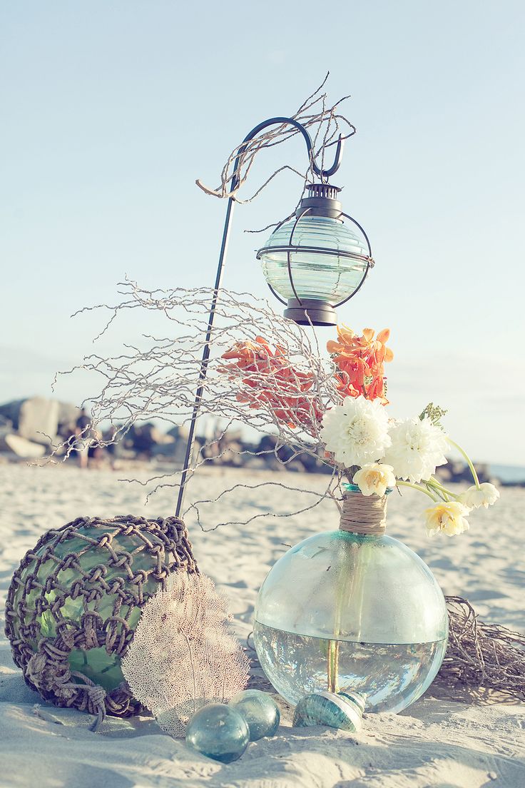 Beach bridal shower decor with floats, a large float vase with blooms and branches and net covering the float
