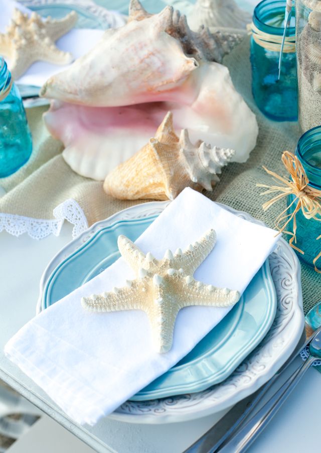 Top your place settings with starfish and put seashells on the table to create a strong beach and seaside feel