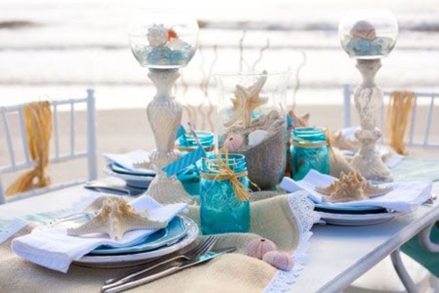 A bright beach bridal shower tablescape done with touches of blue, turquoise, neutral linens, candles and lots of seashells