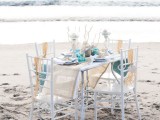 a beach bridal shower tablescape done with driftwood, corals, starfish, seashells and bright touches of turquoise