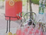 pink lemonade in a tank and bottles with fresh citrus is an ideal drink for a summer bridal shower