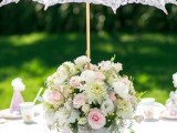 a pastel summer bridal shower with neutral blooms, a lace umbrella, pastel table runners, glasses and cones