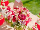bright pink and white blooms and greeneyr in jars plus a burlap table runner for decorating a table