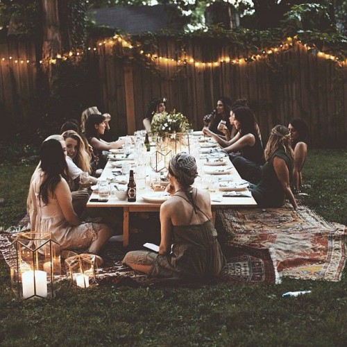 a backyard picnic bridal shower with a low table, rugs, candle lanterns and blooms is a cozy and cool idea