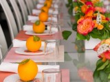 a bright summer bridal shower table with bold blooms and greenery, colorful textiles, citrus with tags