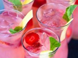 pink punch in glasses, with ice, strawberries and citrus plus some mint is a delicious refreshing drink to try