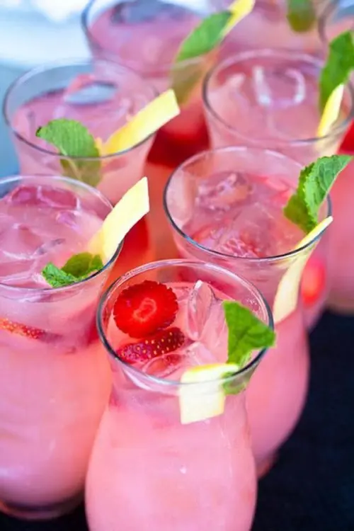 pink punch in glasses, with ice, strawberries and citrus plus some mint is a delicious refreshing drink to try