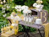 a chic yellow rustic table with lemonade, white blooms, delicious desserts done in yellow and decorated with linens and monograms