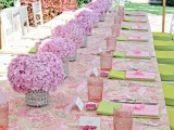 a sweet pink bridal shower table with a printed table, pink glasses and blooms in vases is very elegant and cute