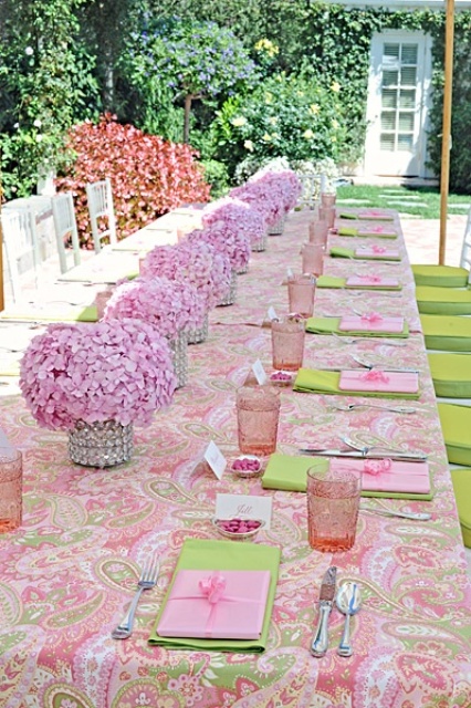 a sweet pink bridal shower table with a printed table, pink glasses and blooms in vases is very elegant and cute