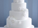 a white wedding cake decorated with white sugar blooms is a timeless dessert for an elegant wedding