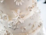 a white wedding cake decorated with white and black edible blooms is a very chic and stylish idea