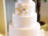 a timeless white wedding cake with ribbons and a large sugar bloom is an elegant dessert for your wedding
