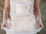 a refined round and square wedding cake decorated with neutral sugar blooms and beads is a stylish and cool idea