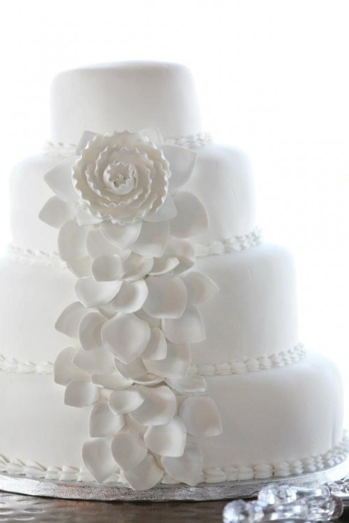 a chic white wedding cake decorated with edible beads and sugar blooms is a stylish and romantic piece to rock