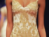a sheath white wedding dress with gold lace appliques and gold straps looks very statement-like