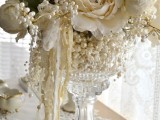 a crystal bowl with pearls, white blooms, leaves and ribbons is a lovely centerpiece for a wedding, with a vintage feel