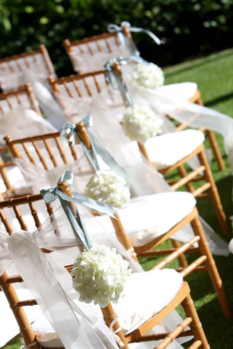white floral topiaries with neutral ribbons hanging on the chairs are perfect for any neutral wedding, not only a spring one