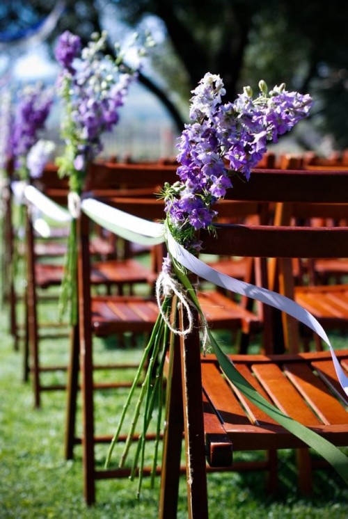 bright purple long stem flower arrangements with lilac ribbons are amazing to style the wedding aisle for a bold spring or summer wedding