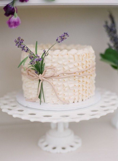 a lovely patterned neutral buttercream wedding cake with a bit of blooms is a beautiful solution for a spring or summer wedding
