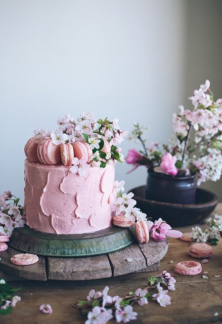 a beautiful pink textural buttercream wedding cake topped with macarons and pink cherry blossom is a lovely solution for a spring wedding