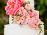a white textural buttercream wedding cake with pink and peachy blooms and greenery is a cool idea for a spring or summer wedding