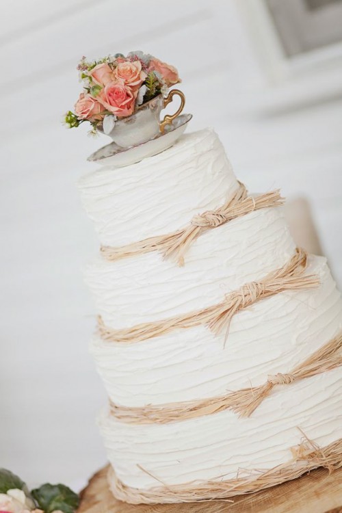 a white textural wedding cake with straw and bold blooms and greenery in a vintage teacup is amazing