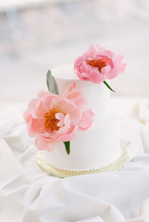 a delicate white buttercream wedding cake topped with pink peonies is a gorgeous idea for a spring or summer wedding with a refined feel