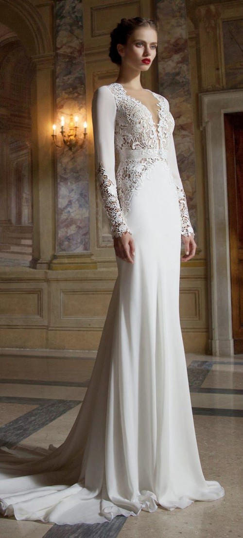 a romantic wedding dress of plain fabric and with lace inserts, a plunging neckline, long sleeves and a train