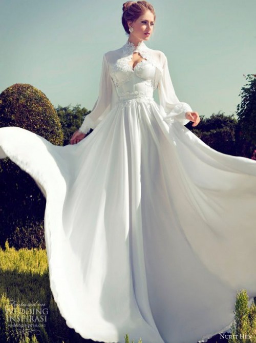 a beautiful and romantic wedding dress of plain fabric, with lace detailing, a pleated skirt and a matching coverup with long sleeves