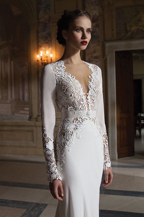 a stylish vintage wedding dress of plain fabric, with lace detailing and inserts and a plunging neckline is very sexy