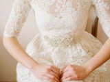 a vintage-inspired lace A-line wedding dress with a high neckline and short sleeves plus an embellished sash