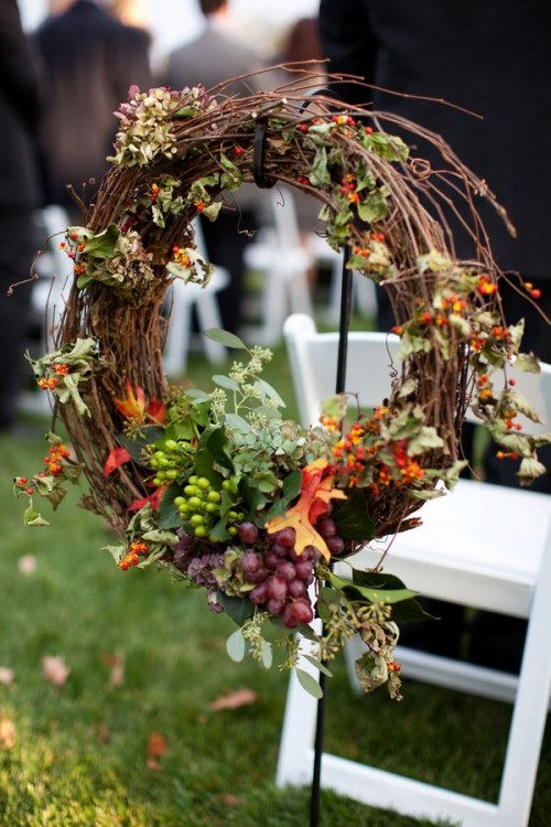 a fall vineyard wedding wreath of bright leaves, greenery, berries, grapes is a pretty decoration for any part of your venue