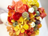 a super bold fall wedding bouquet of yellow, red, rust, pink blooms, billy balls and some berries is a lovely solution for any kind of a fall wedding