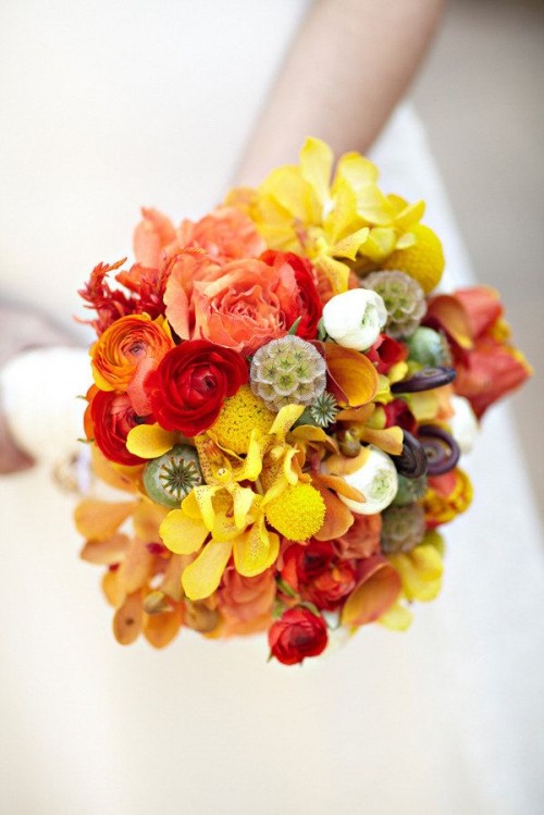 a super bold fall wedding bouquet of yellow, red, rust, pink blooms, billy balls and some berries is a lovely solution for any kind of a fall wedding