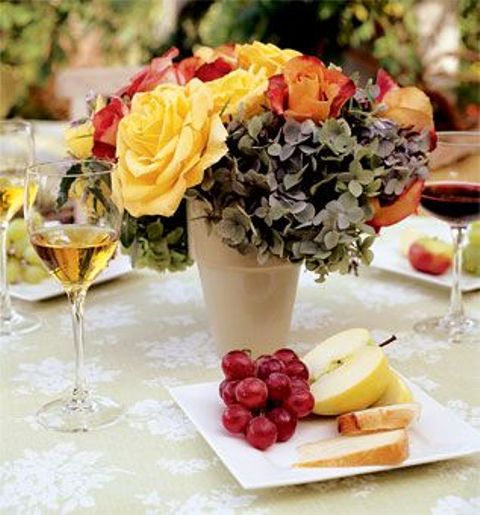 a bold fall vineyard wedding tablescape with bright flowers and greenery, with fresh fruit and vine will be lvoed by the guests a lot