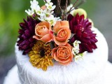 a white lace wedding cake topped with bright fall blooms is an elegant and chic idea for a fall wedding, whether it’s a vineyard one or not