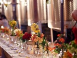 a bright fall wedding tablescape with bold flowers and greenery as a cluster wedding centerpiece, candles and all white everything for a chic and elegant look