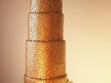 an outstanding gold penny wedding cake with sugar ruffles at the bottom and some Japan inspired sugar decor
