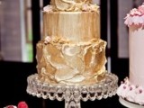 a crazy textural gold wedding cake with petals is a stylish and bold idea to go for